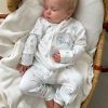 Baby White Sailboat Onesie Sleeping Baby sleeping in personalised white sailboat print zip romper in a wicker moses basket.