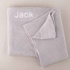 A light grey knitted baby blanket personalised with the name Jack