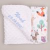 White forest minky blanket with printed animals, folded and embroidered with name Noah in blue, grey background.