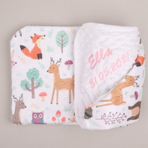 White forest minky blanket with printed animals, folded and embroidered with name Ella in pink, grey background.