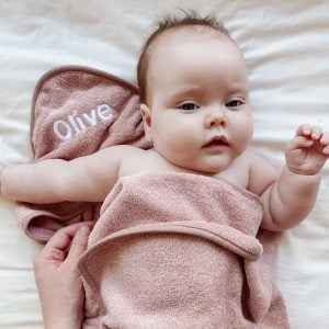 Baby Olive wrapped up in Personalised blush pink towel newborn girl gift.