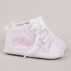 Personalised white baby shoes embroidered with the name Ava with grey background