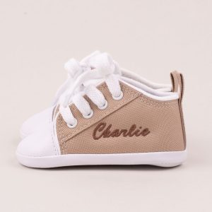 Sand coloured baby shoes personalised with the name Charlie using brown thread.