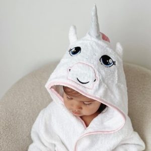 A baby girl wearing a personalised unicorn robe with hood.