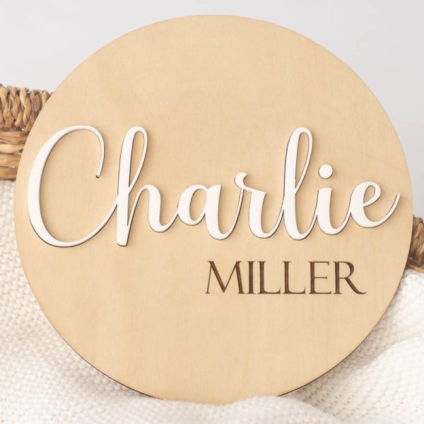 Wood and acrylic birth announcement disc with the name Charlie showing in white.