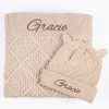 Personalised beige diamond knit baby blanket folded with matching bear ear beanie both embroidered with the name Gracie in brown