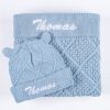 Personalised blue diamond knit baby blanket and matching bear ear beanie laid flat showing embroidered name Thomas.