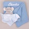Personalized blue baby blanket and elephant comforter embroidered with the name “Charlie.”