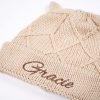 Diamond Beige Knitted Baby Beanie. Close Up Close up of a beige diamond knit baby beanie with bear ears showing brown embroidered name Gracie on the cuff