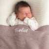 Dusty Lilac Knitted Baby Blanket Violet Baby sleeping under personalised dusty lilac knitted cotton newborn blanket embroidered with girls name Violet.