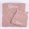 Personalised Blush Pink Diamond Blanket & Beanie Set. Olivia Personalised Blush pink cable knit baby blanket folded with matching bear ear beanie showing embroidered name Olivia