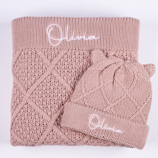 Personalised Blush Pink Diamond Blanket & Beanie Set. Olivia Personalised Blush pink cable knit baby blanket folded with matching bear ear beanie showing embroidered name Olivia