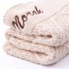 A Personalised Cream Diamond Baby Blanket embroidered with the name Norah.