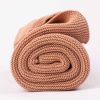 dusty-peach-rolled-personalised-knitted-baby-blanket Dusty Peach Knitted Personalised Baby Blanket rolled up and photographed side on.
