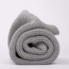 Personalised Grey Knitted Baby Blanket rolled up and photographed side on.