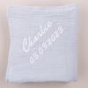 LIght blue muslin swaddle wrap embroidered with Charlie and his date of birth.