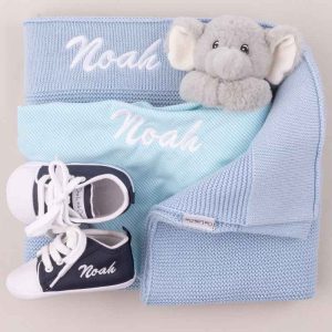 A personalised baby boy gift including knitted blanket, shoes and elephant comforter all embroidered with Noah.