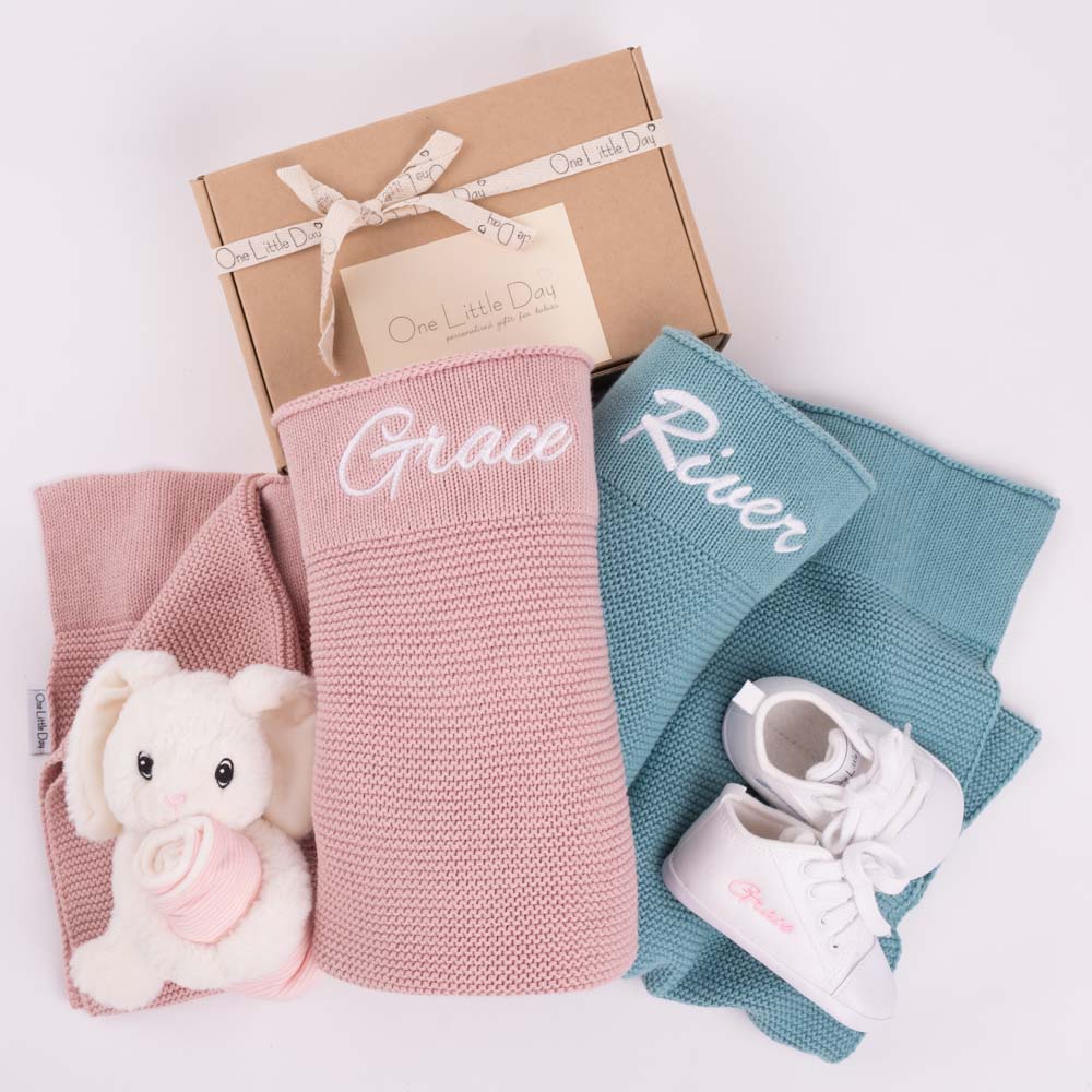 Two personalised knitted baby's blankets, a bunny comforter and a pair or personalised baby shoes