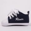 Personalised navy blue baby shoes embroidered with the name River & zoomed in