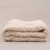 A folded cream diamond knitted blanket