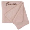 A personalised beige baby blanket embroidered with Charlie.