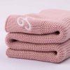 A Personalised Blush Pink Knitted Baby Blanket for girls folded and photographed from the side.