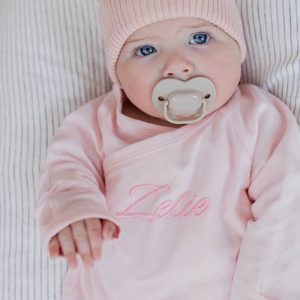 Zelie wearing personalised pink baby onesie for girls.