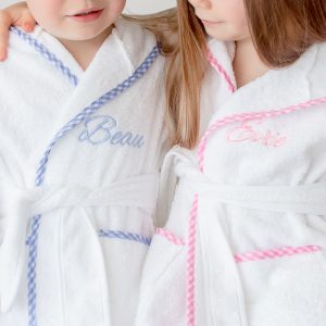 Boy and Girl wearing the blue and pink gingham personalised hooded robe1 year old gift.