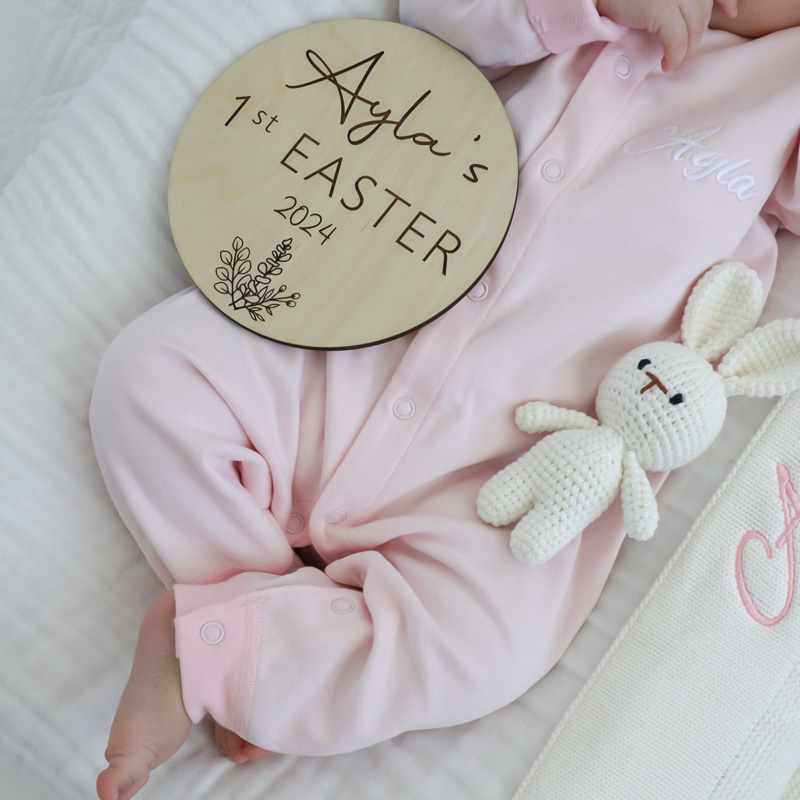 An Easter Baby disc laying on a baby next to a cute bunny rattte.