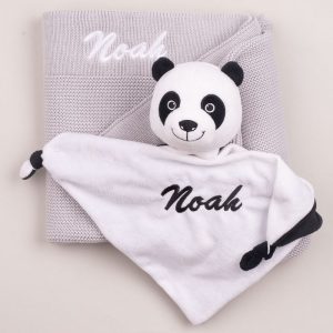 A light grey knitted blanket and panda comforter newborn gift.