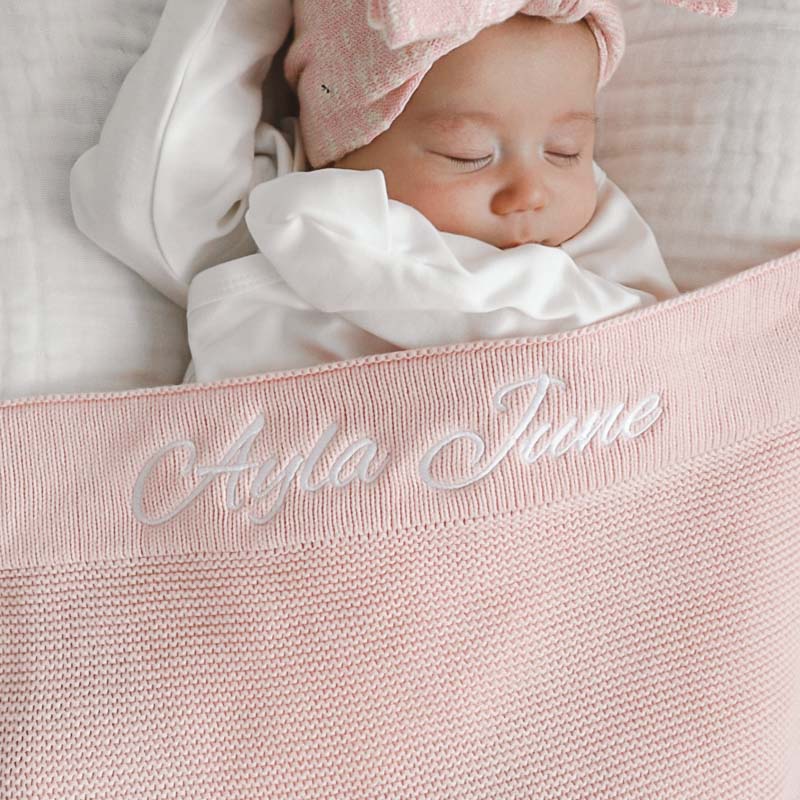 Baby girl with personalised pink knitted blanket unique gift.