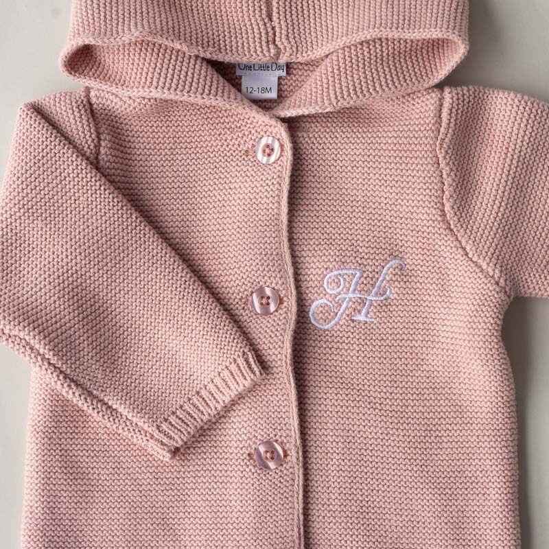 Close Up of a Blush Pink Baby Cardigan with the letter H embroidered.