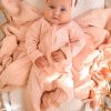 Personalised Pink Zip Baby Onesie Peyton Personalised pink zip footed onesie with Peyton embroidered in white on baby lying on muslin wrap