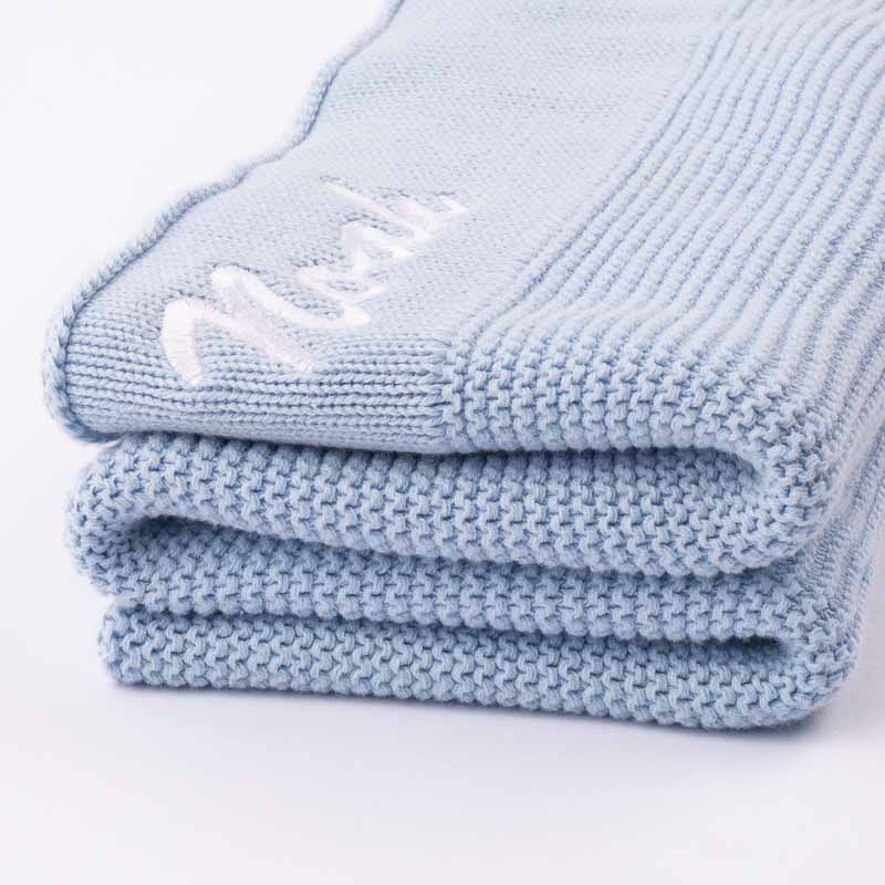 Personalised blue knitted blanket for boys folded.
