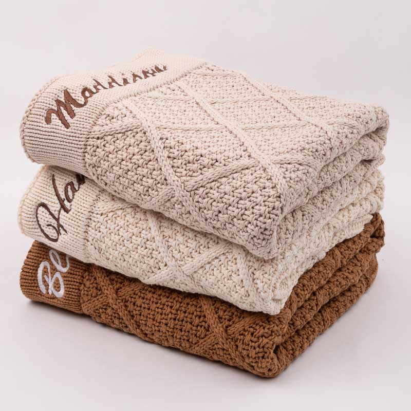 Personalised diamond knitted baby blankets stacked on top of each other unique gift for newborns.