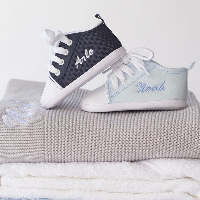 Personalised baby boy shoes on blankets with name embroidery.