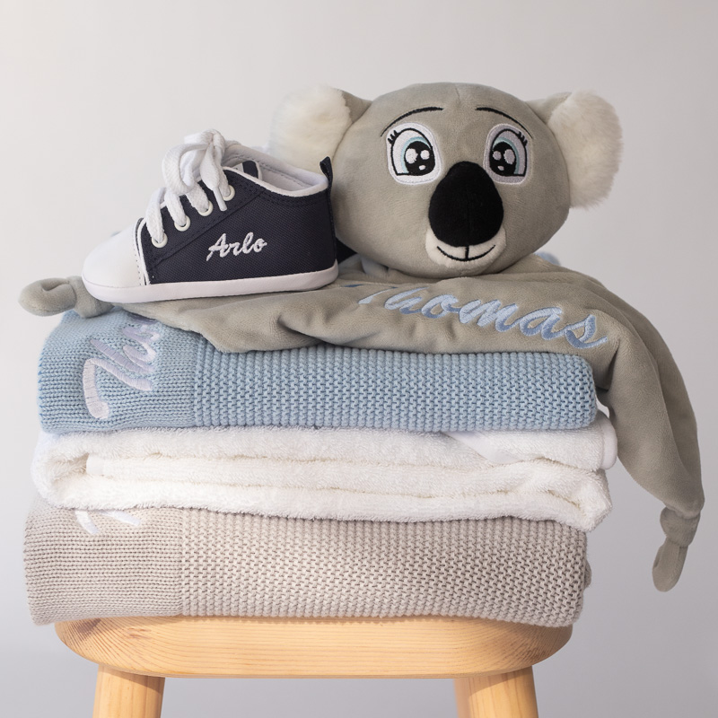 Personalised Baby Boy Gift Ideas folded neatly on a chair.
