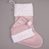 Light Pink Christmas Stocking & Hat Baby Gift Set Olivia Light pink velvet personalised baby Christmas stocking and matching Santa hat with white cuffs, pompom and pink embroidered script name on grey background.