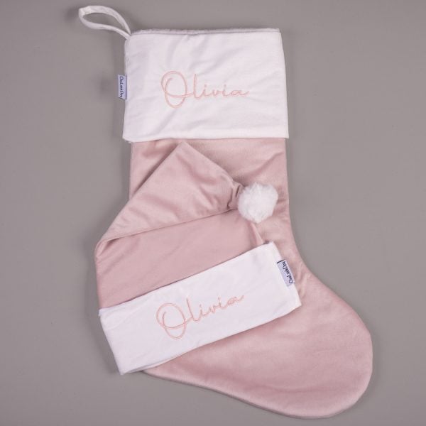 Light Pink Christmas Stocking & Hat Baby Gift Set Olivia Light pink velvet personalised baby Christmas stocking and matching Santa hat with white cuffs, pompom and pink embroidered script name on grey background.