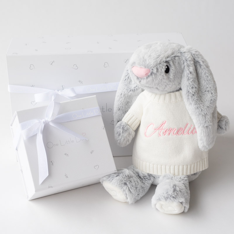Grey plush bunny in personalised jumper, sitting beside two white gift boxes tied with white ribbons.