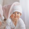 Baby wearing personalised pink Christmas hat with name embroidery from One Little Day.