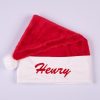 Red Christmas Baby Hat Henry Red faux fur personalised baby Santa hat with white cuff, pompom and red embroidered script name on white background.