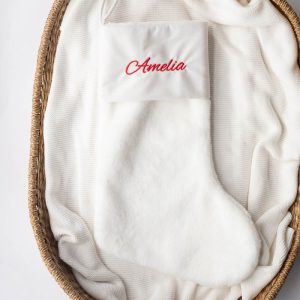 White Christmas baby stocking embroidered with the name Amelia in red.