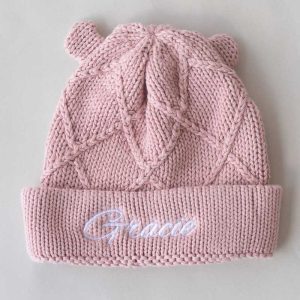 Blush pink knitted baby beanie with diamond pattern, bear ears, and personalised embroidered name