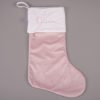 Large light pink velvet personalised Christmas stocking with cream cuff and pink embroidered script name on grey background.