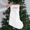 Personalised white faux fur Christmas stocking with Amelia embroidered in red.