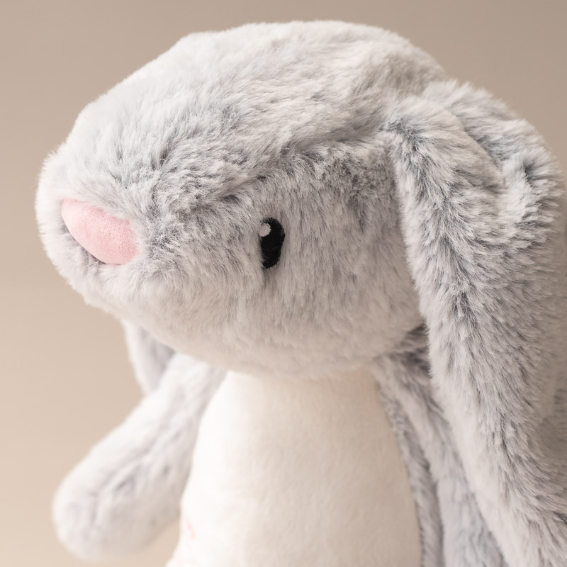 Soft grey bunny plush toy with floppy ears and pink nose.
