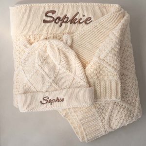 Cream knitted baby blanket and beanie with diamond pattern, personalised with the embroidered name Sophie.