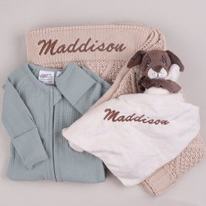 Personalised baby gift set with beige knitted blanket, sage onesie, and puppy comforter embroidered with the name Maddison.