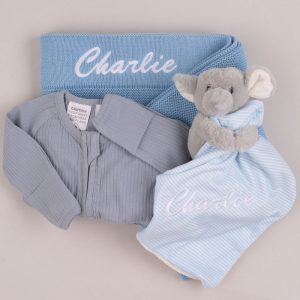 Blue personalised baby gift set with blanket, romper, and elephant comforter embroidered with the name Charlie.